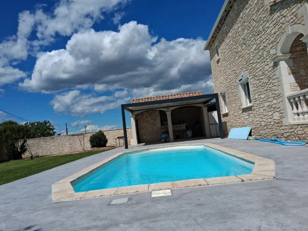 Pergola classique toiture fixe en aluminium Akraplast avec store vertical Mecanotoldo à Saint-Laurent-des-Arbres vue de la piscine