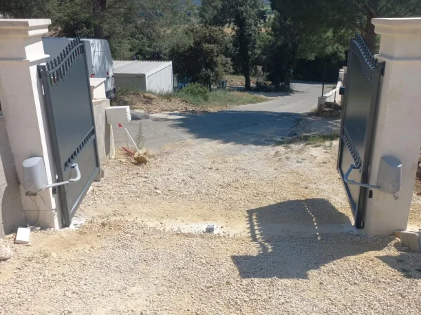 Portail battant motorisé et portillon gris aluminium fer forgé La Toulousaine à Montfaucon vue intérieure ouvert