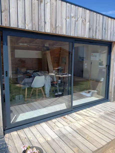 Baie coulissante 2 vantaux RAL 7016 aluminium Schüco sur maison en bois à Bagnols-sur-Cèze vue extérieure
