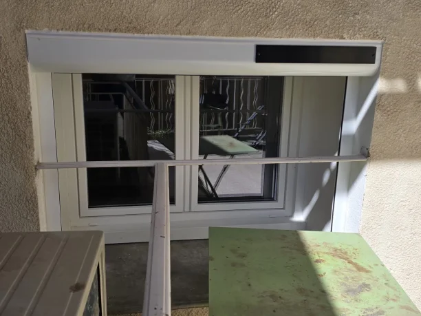 Petite fenêtre blanche PVC Réhau et volet roulant solaire Profalux Saint-Étienne-des-Sorts vue extérieure