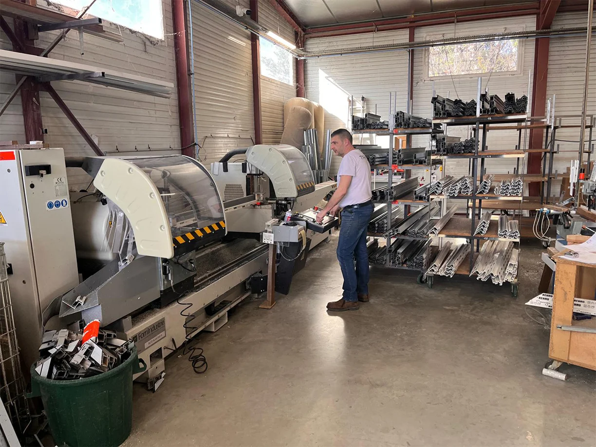 TRIOLA Menuiseries atelier de fabrication à Laudun l'Ardoise : scie double tête aluminium