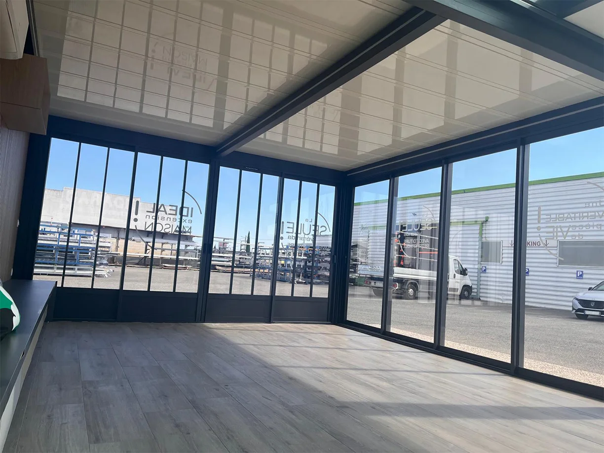 Véranda extension aluminium toit rétractable Ciel Ouv’air Carré 2 Rêve showroom TRIOLA vue intérieure toit fermé