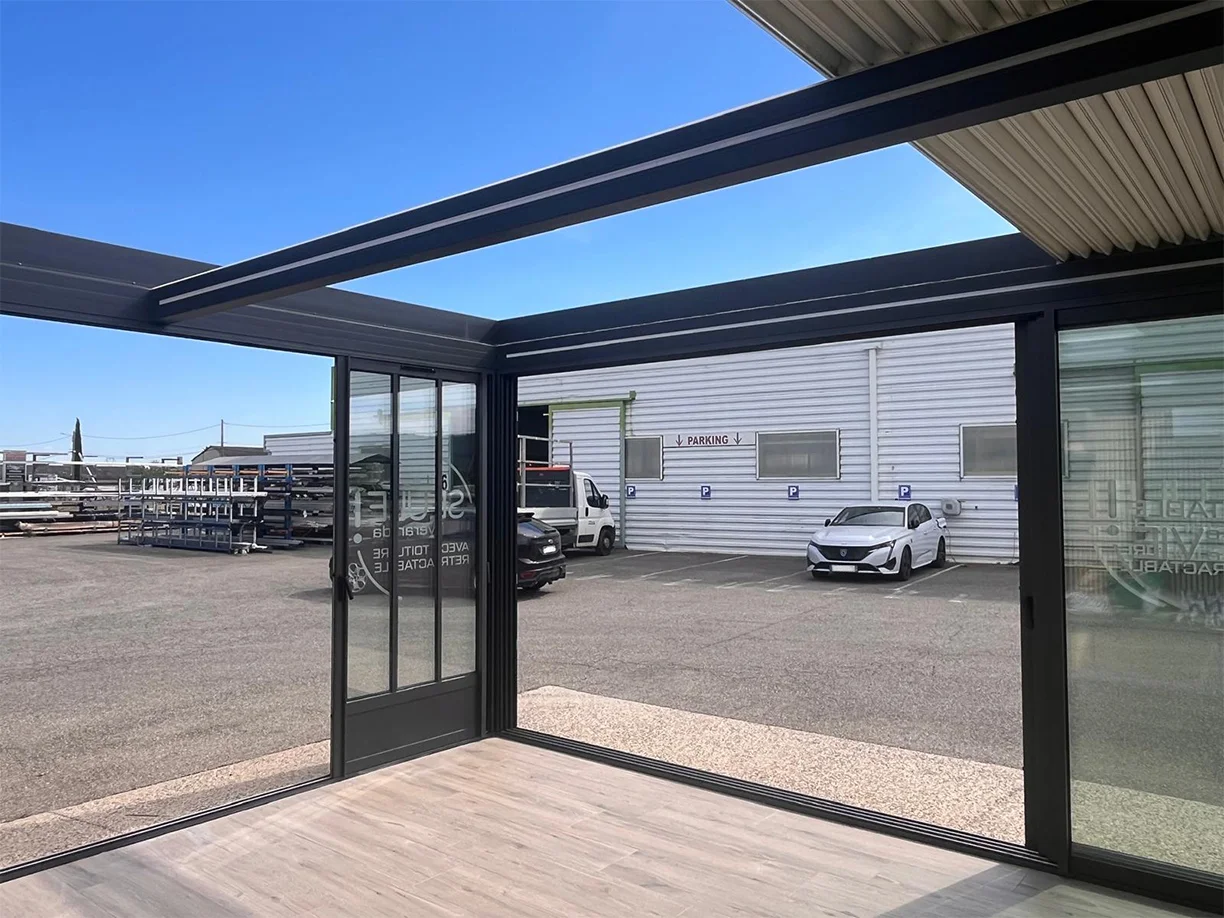 Véranda extension aluminium toit rétractable Ciel Ouv’air Carré 2 Rêve showroom TRIOLA vue intérieure ouvert latérale