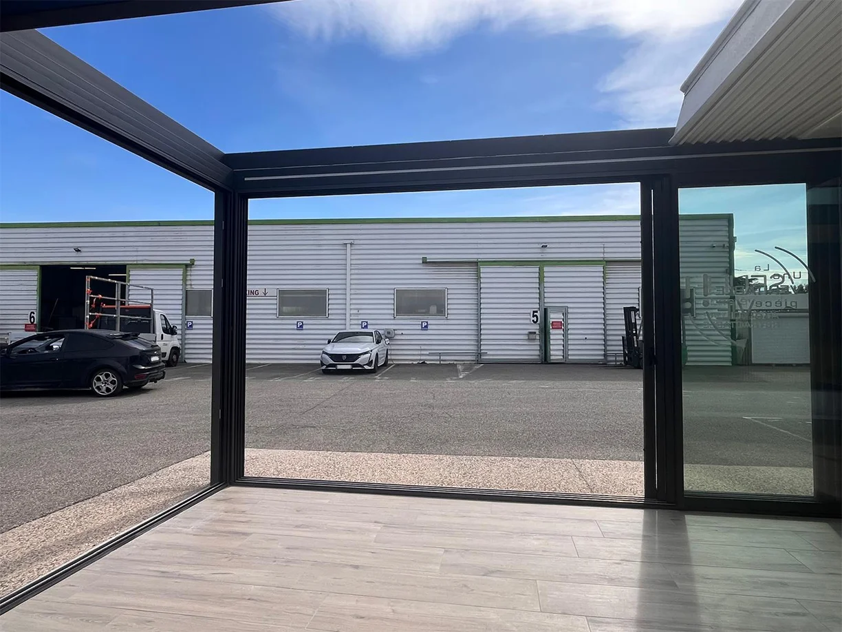 Véranda extension aluminium toit rétractable Ciel Ouv’air Carré 2 Rêve showroom TRIOLA ouvert de face