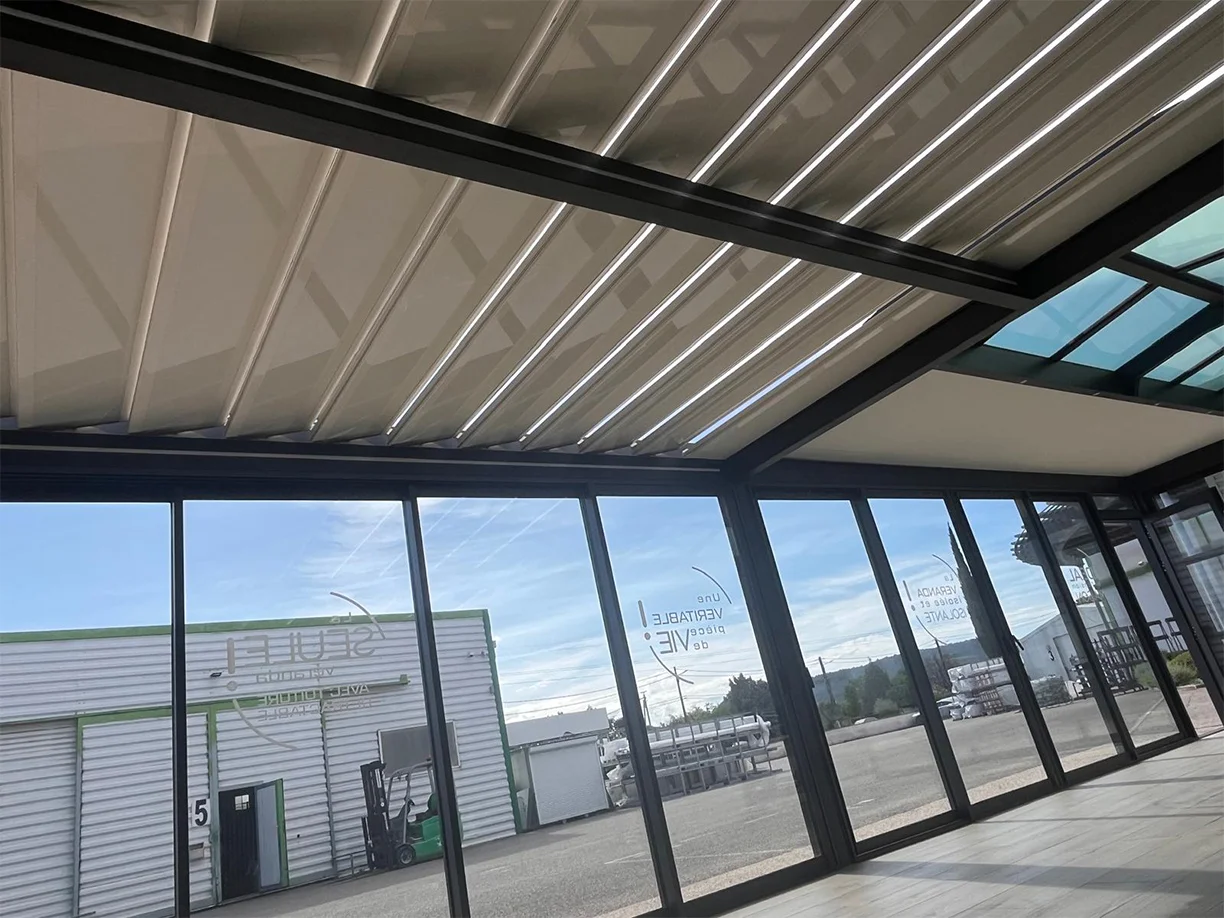 Véranda extension aluminium toit rétractable Ciel Ouv’air Carré 2 Rêve showroom TRIOLA vue intérieure