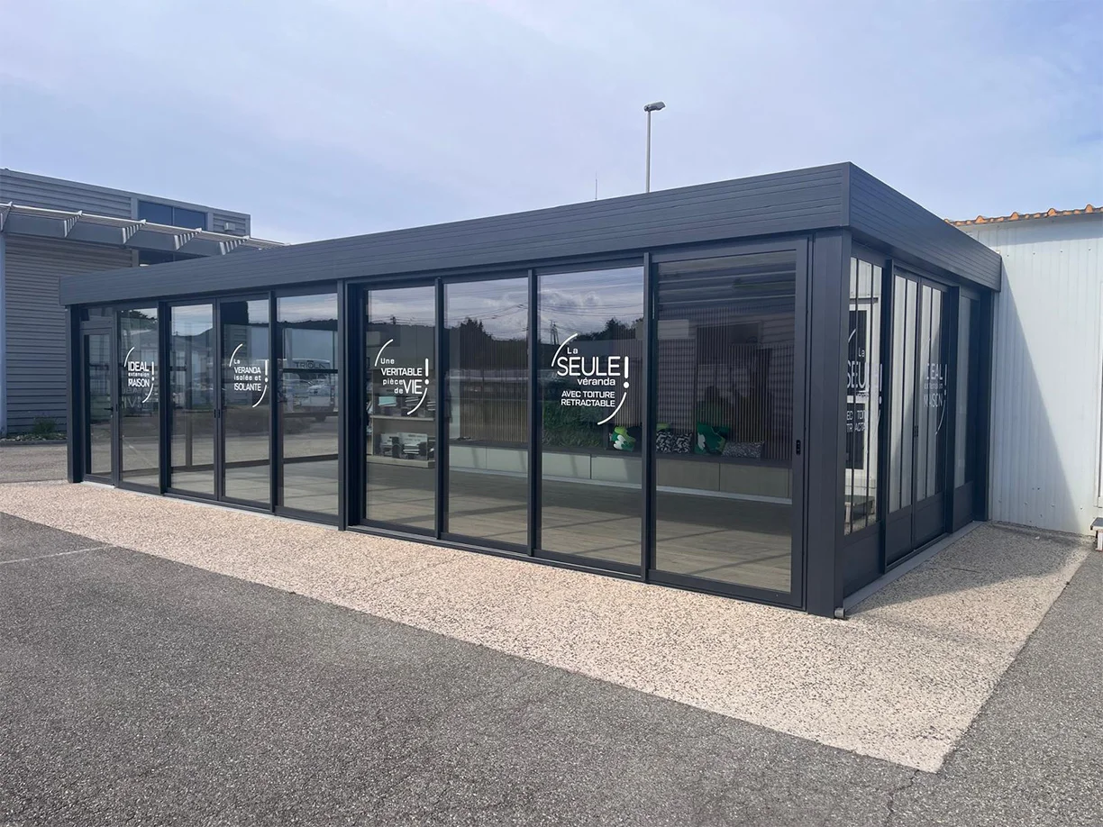 Véranda extension aluminium toit rétractable Ciel Ouv’air Carré 2 Rêve showroom TRIOLA vue extérieure latérale